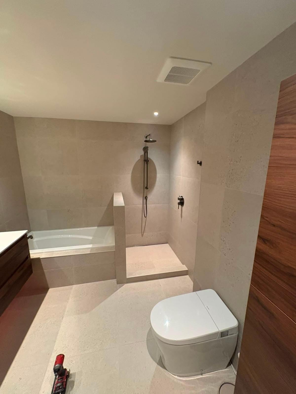 Salle de bain avec douche à l'italienne, bain autoportant et toilette suspendue